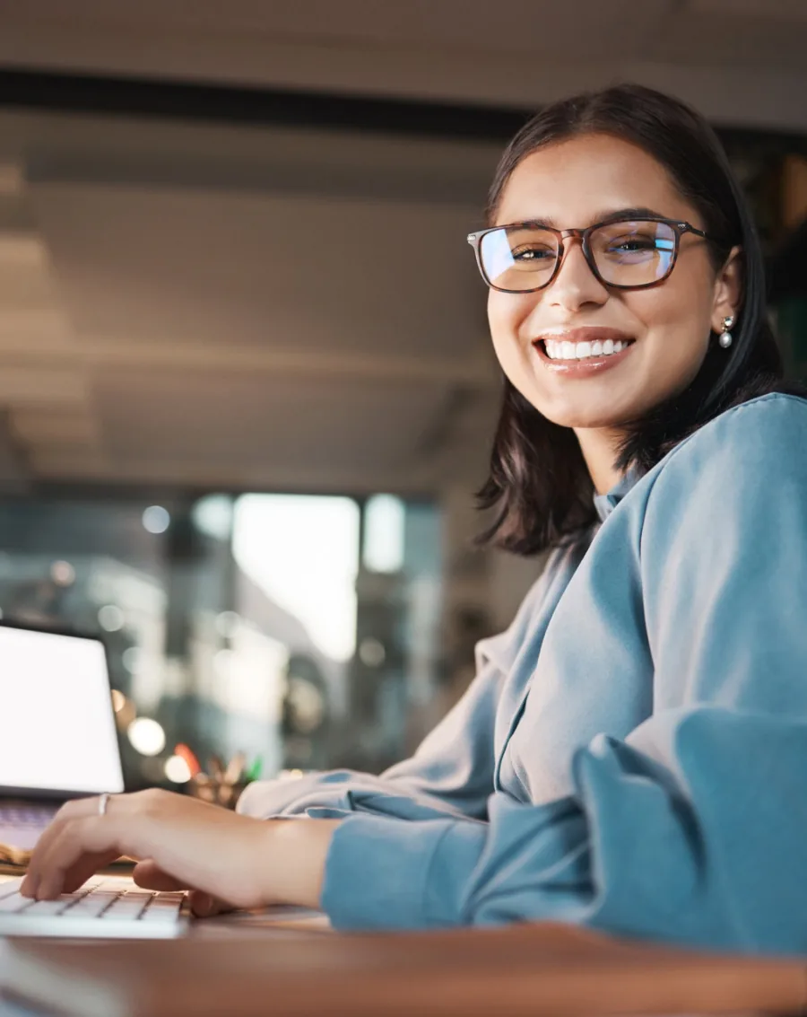 Technical support specialist smiling while working at a laptop